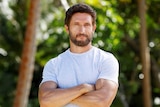 An actor posing for a portrait in front of a jungle