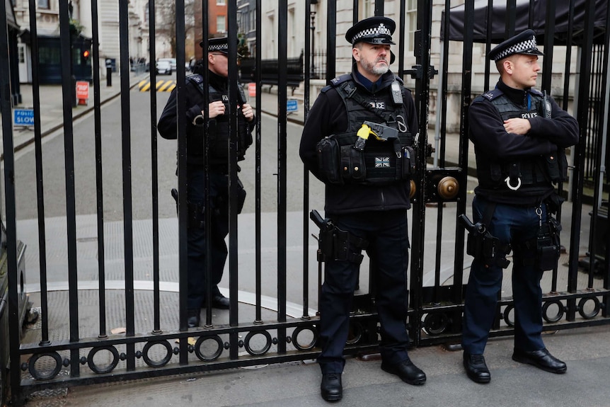 Police officers guard the gates to Downing Street in London.