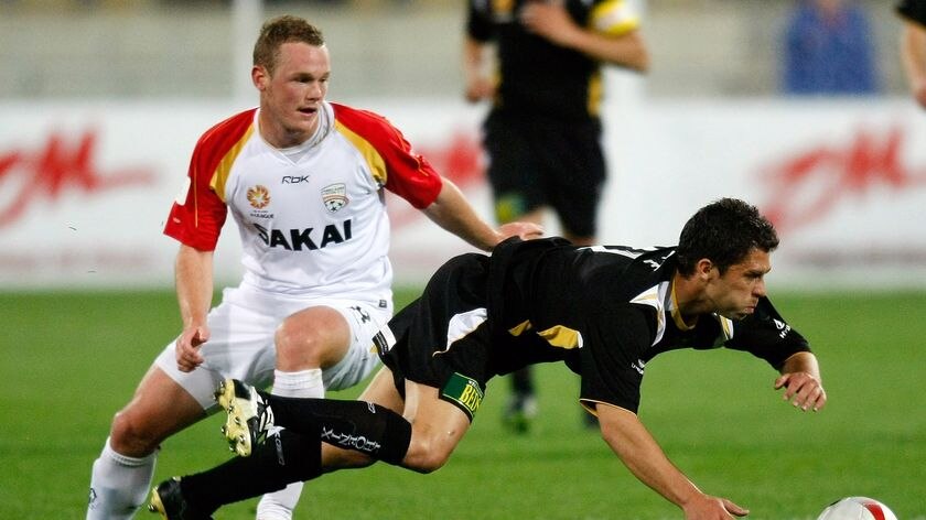 Phoenix forward Felipe takes a fall as United recruit Kristian Sarkies looks on