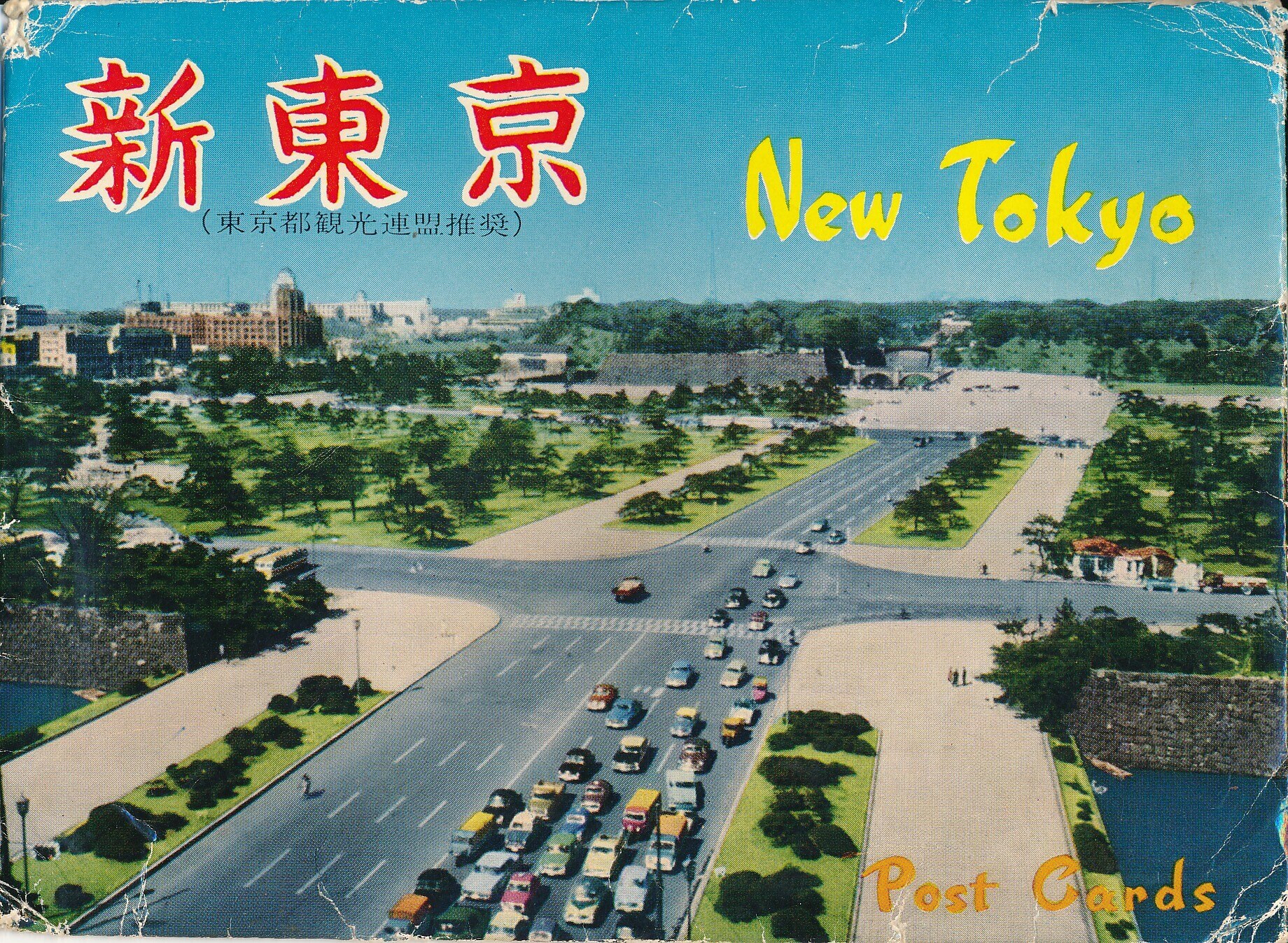 An old postcard from Tokyo with cars on a large street.