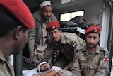 Army soldiers shift a man injured by a suicide bombing in Pakistan
