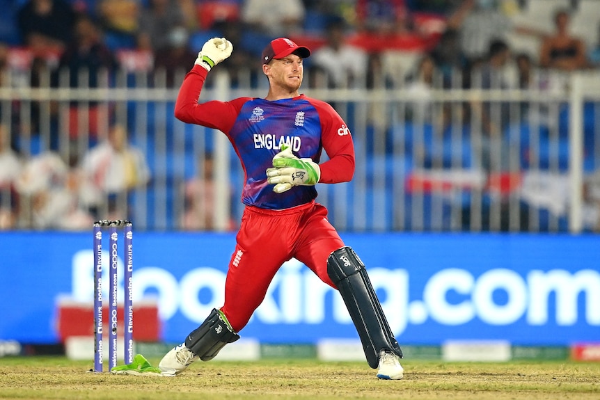 Jos Buttler stands in the action of throwing with the ball in his hand, cocked behind his head