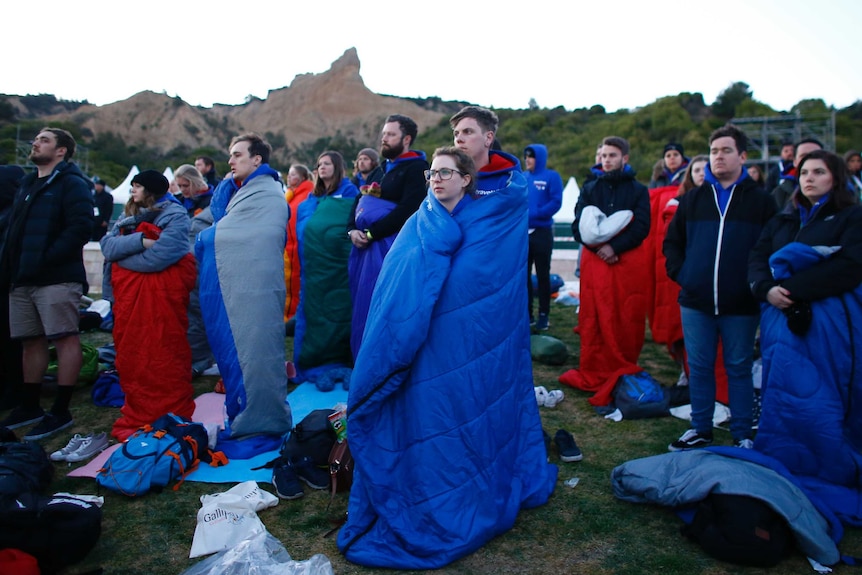 People wrapped in blankets watch the Anzac Day dawn service at Gallipoli.