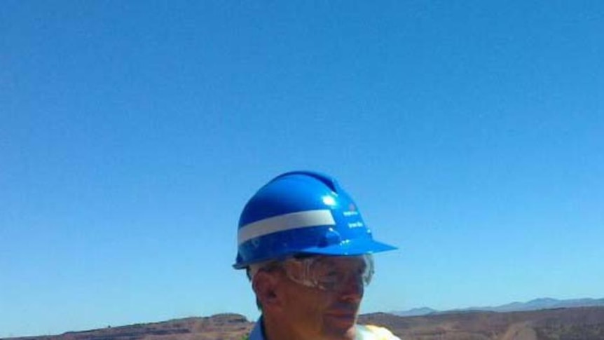 Tony Abbott stands at a lookout at BHP's Mount Whaleback mine near Newman under a bright blue sky
