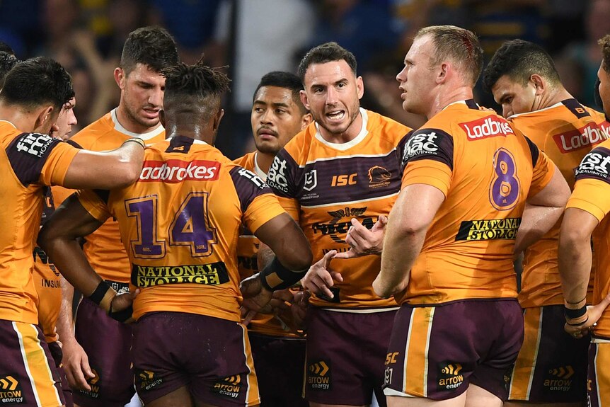 Darius Boyd shouts at his stunned-looking teammates wearing yellow jerseys in a huddle