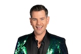 Man wearing a sparkly green jacket over a black shirt.