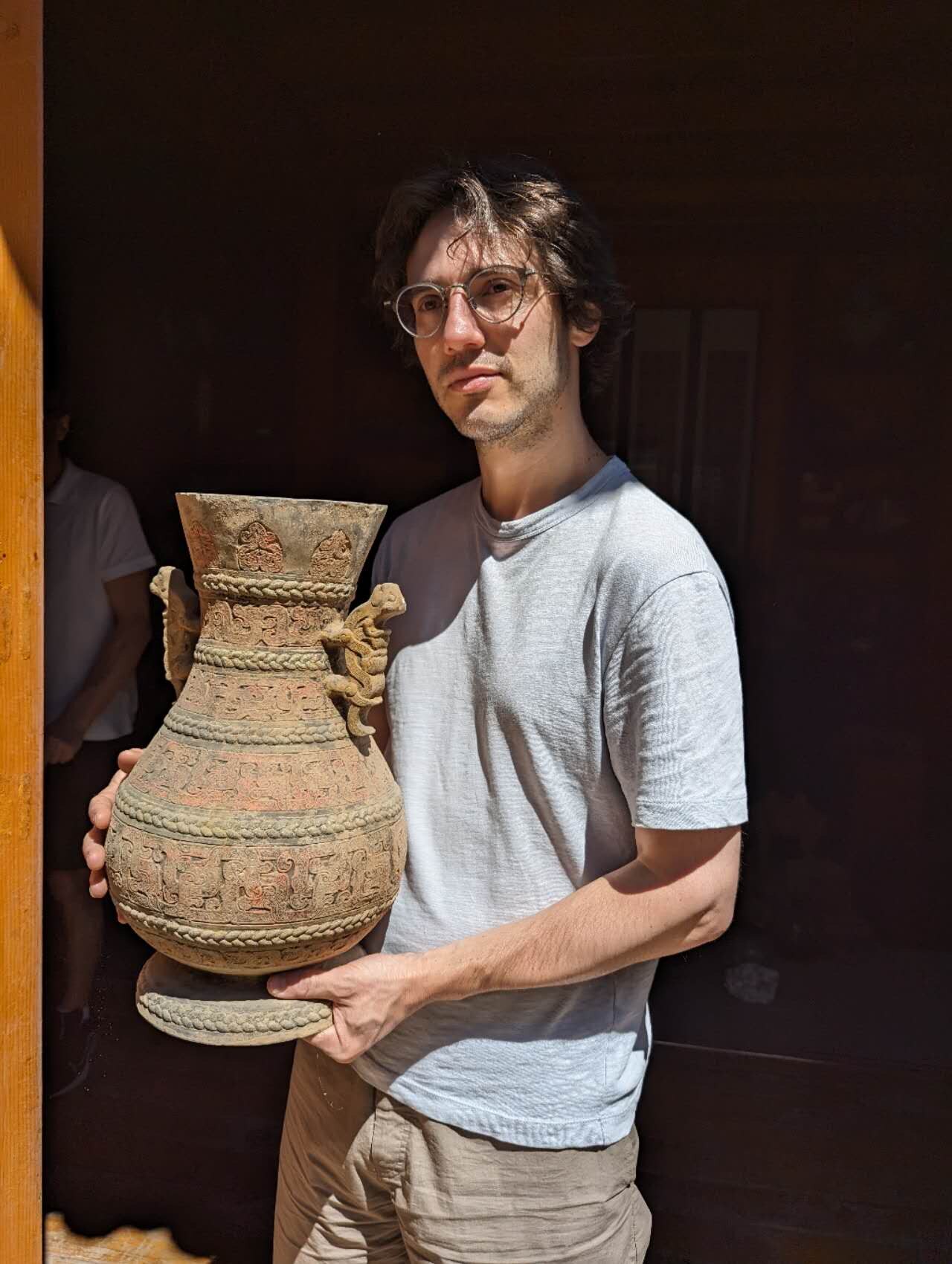 A man holding an antique vase