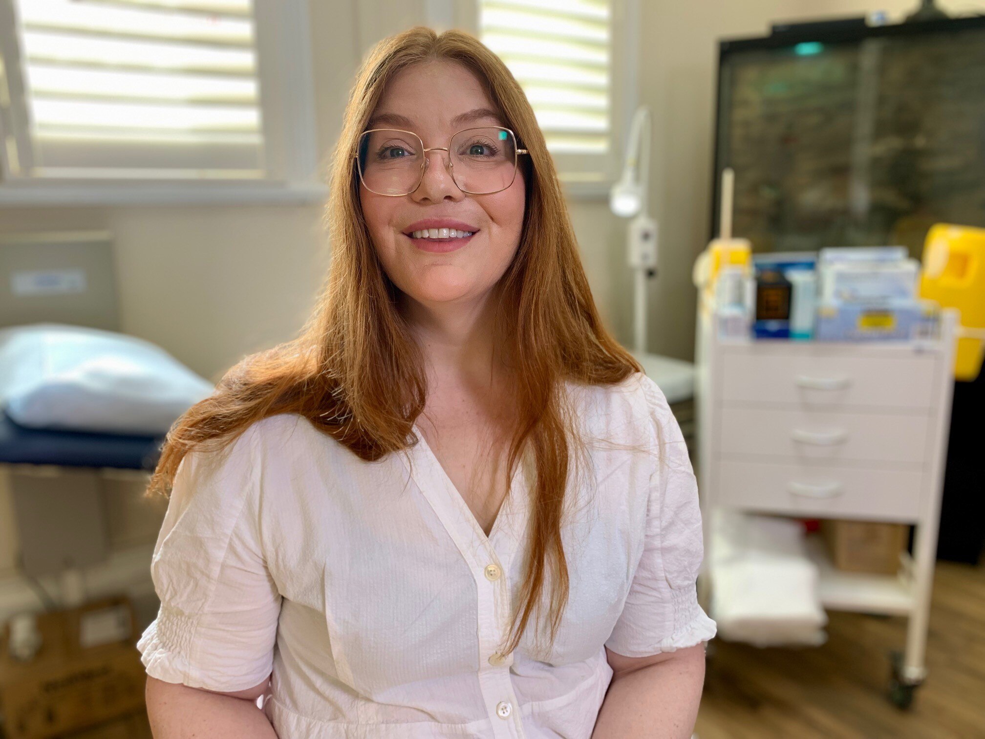 A woman sits in a doctors office.
