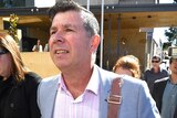 Former Ipswich Mayor Andrew Antoniolli and his wife leave the Ipswich Magistrates Court surrounded by media in 2019.