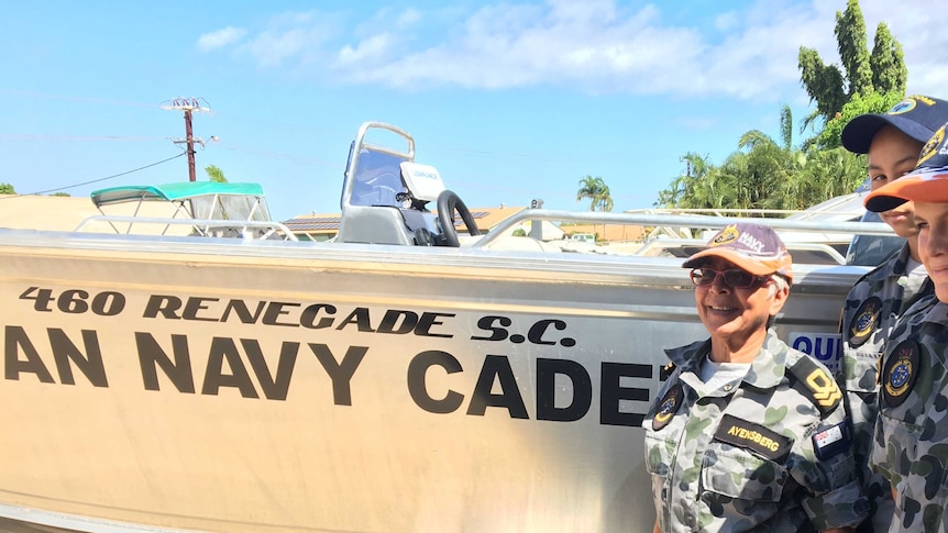 Persine Ayensberg stands beside a new navy cadet boat