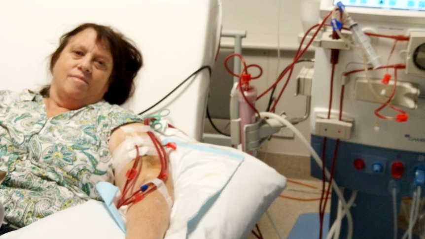 Lea Russ lying in a hospital bed, with multiple IV tubes hooked up to one arm.