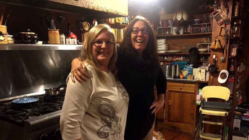 A republican voter and a democrat stand together in a home kitchen