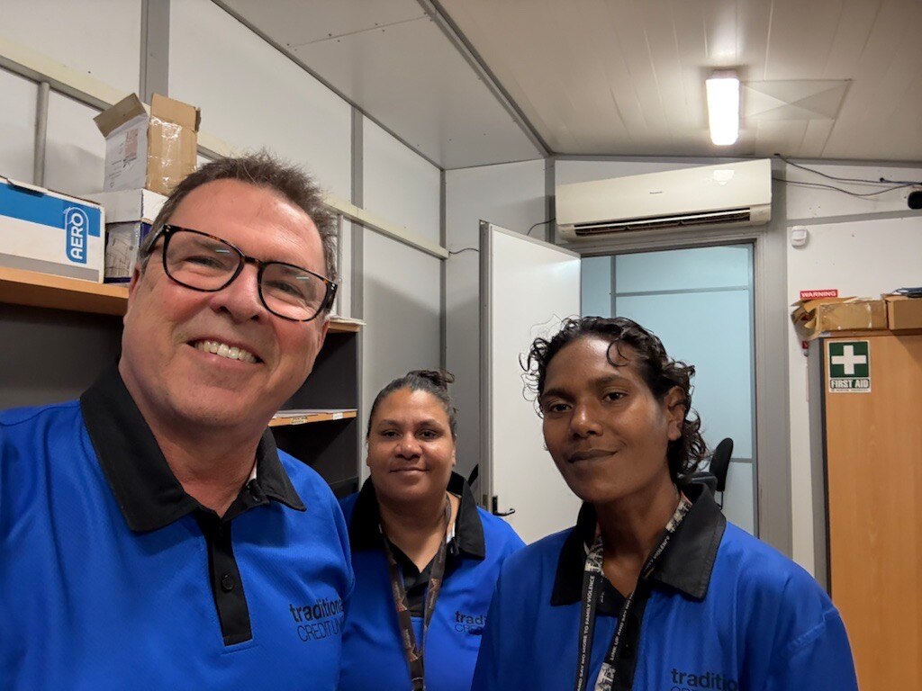 Tres personas paradas en un almacén frente a las cajas.