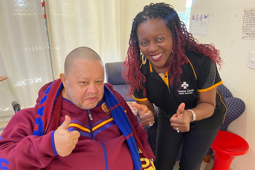 Robert Borey and Busi Faulkner smile while giving a thumbs up