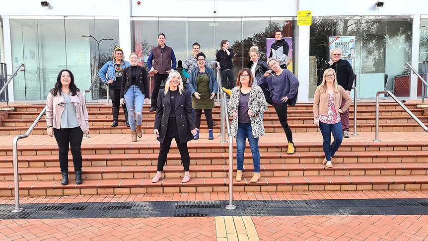 Singing in quarantine members stand on the steps of the Albury Entertainment Centre