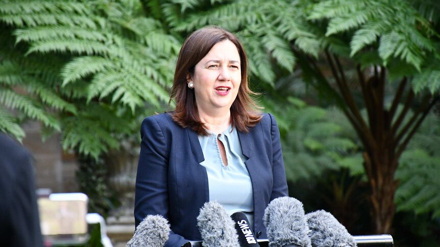 Queensland Premier Annastacia Palaszczuk in front of microphones.