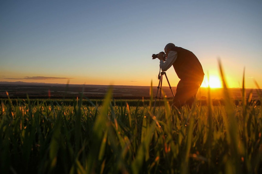 Kingaroy resident John Dalton takes a photo of the landscape in Kingaroy region in southern Queensland at sunset