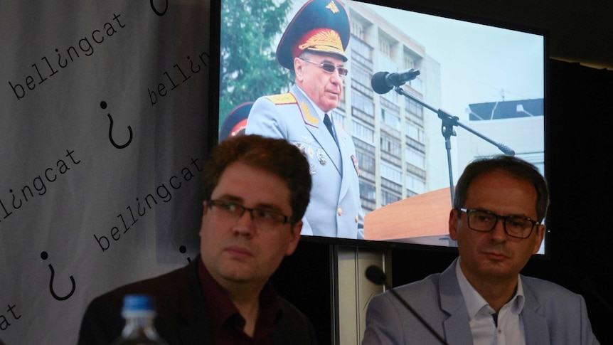 Eliot Higgins, founder of Bellingcat sits in front of screen projecting image of Russian Colonel General Delfin.