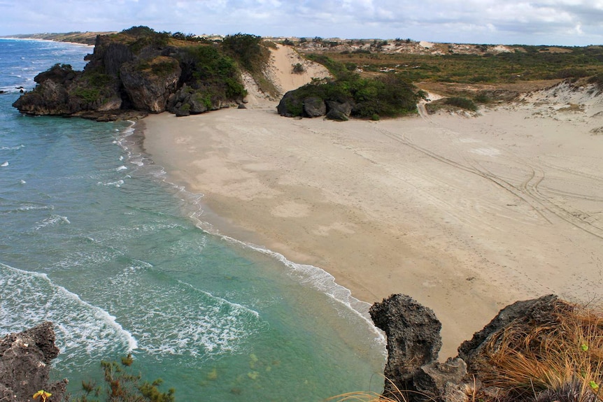 A high-angle shot of a clean stretch of Caves Beach, with the ocean nearby.