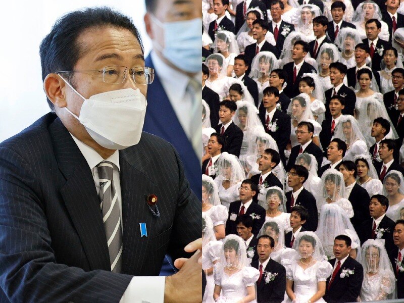 On left a Japanese man in suit and face mask sits at table, on right is a crowd wearing traditional bridal attire.