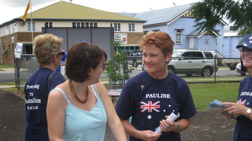 Pauline Hanson (r) hands out how to vote cards in Boonah, Saturday, March 20, 2009. Queenslanders go to the polls today in the 2009 state election.