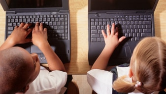 File photo: Boy and girl using laptops side by side (Getty Creative Images)