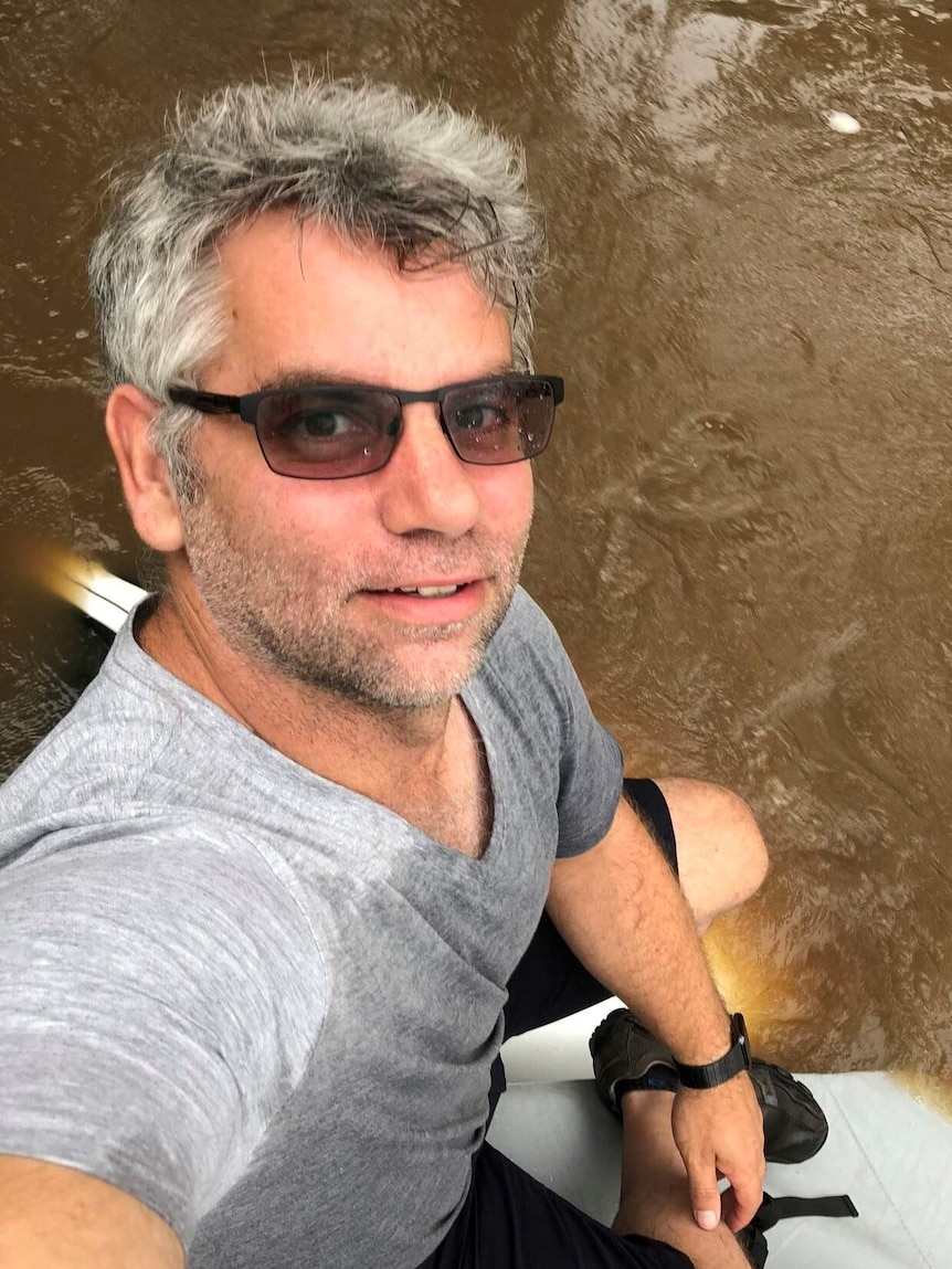 Adrian Hastwell-Batten sits on the roof of his car