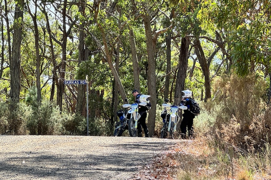 Police officers with motorcycles on the edge of bushland