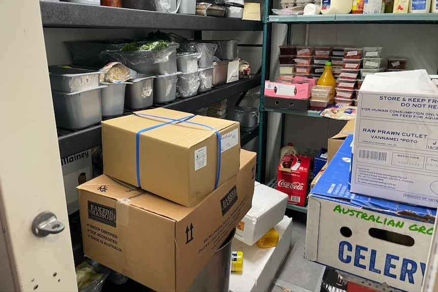 Boxes of food in a fridge in a cold room.