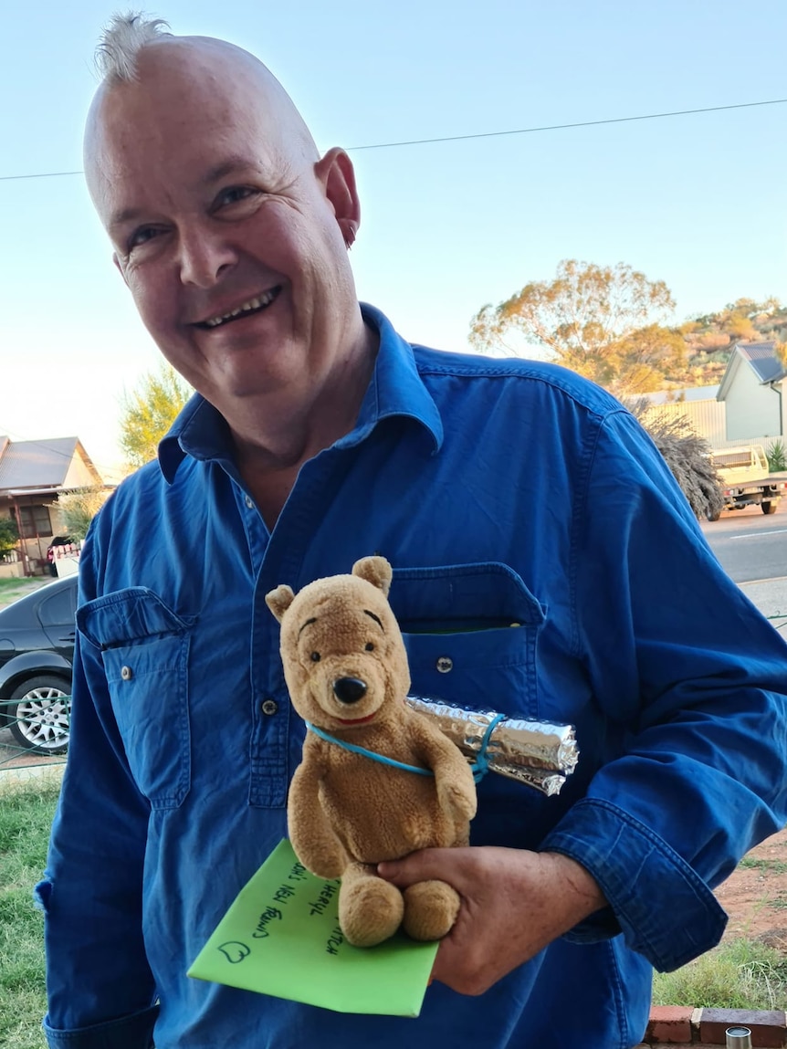 Grazier Mitch Rodgers and teddy bear 'Pooh' pose for a photo