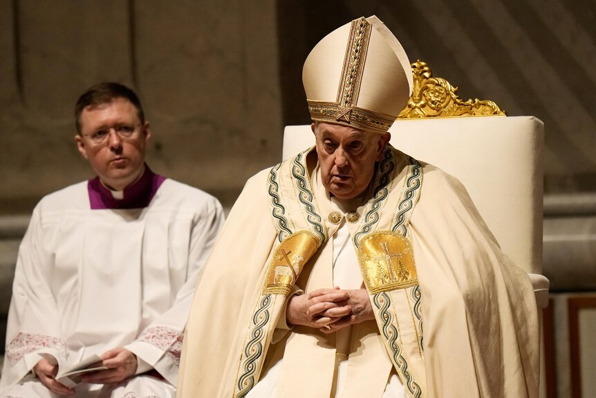 Pope Francis presides over the Easter vigil celebration. He has a vacant stare and looks like he's falling asleep.