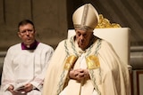 Pope Francis presides over the Easter vigil celebration. He has a vacant stare and looks like he's falling asleep.
