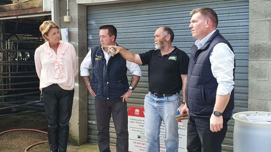 Three NSW politicians stand with a farmer.