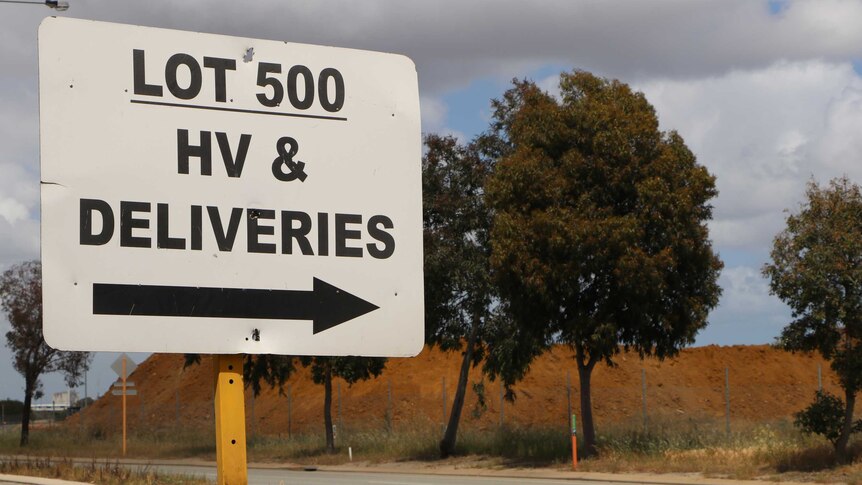 A street sign reads Lot 500 HV & Deliveries, with trees and sky in the background.