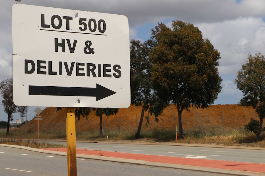 A street sign reads Lot 500 HV & Deliveries, with trees and sky in the background.
