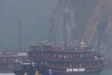 A police boat sits next to the submerged tourist boat that sunk in Halong Bay