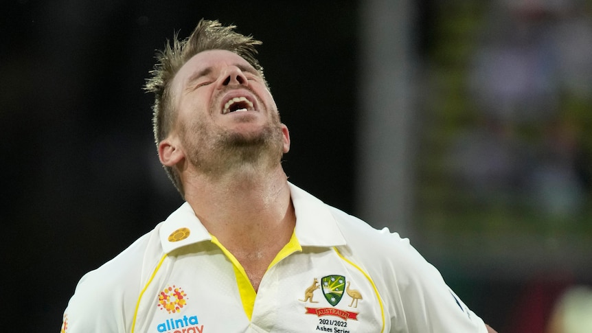 David Warner tilts his head back, with his mouth open and eyes closed