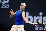 Rafael Nadal in a blue tank top and white hat plays a shot at the Brisbane International