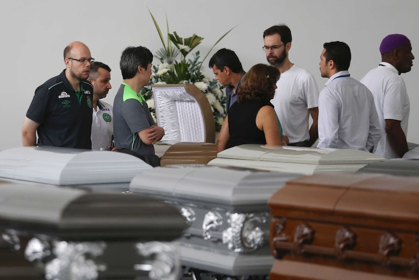 Chapecoense board members look over coffins of players in Colombia