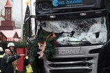 Firefighters point at bus that rammed Christmas market in Berlin