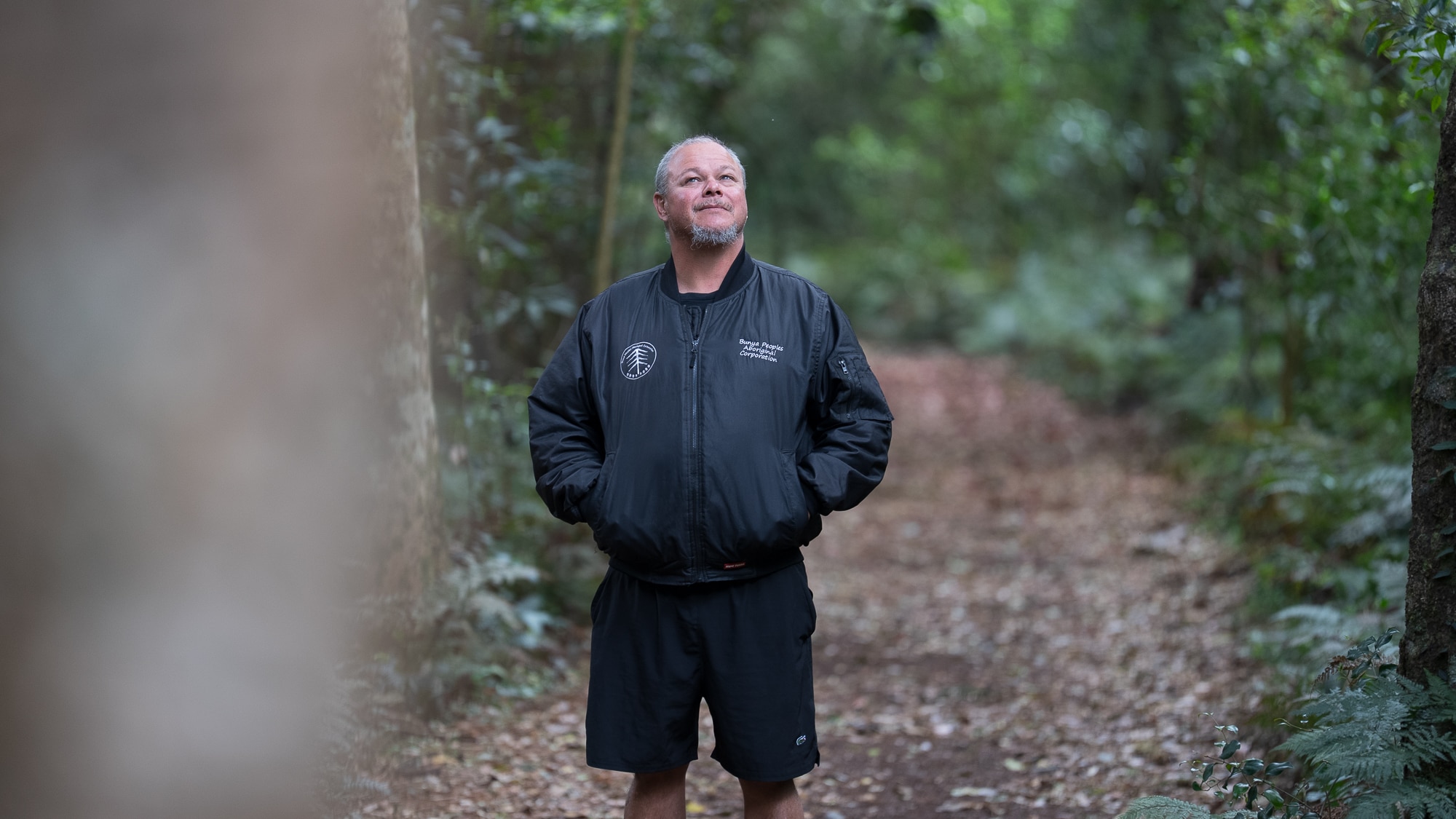 Shannon Bauwens stands in the forest looking up