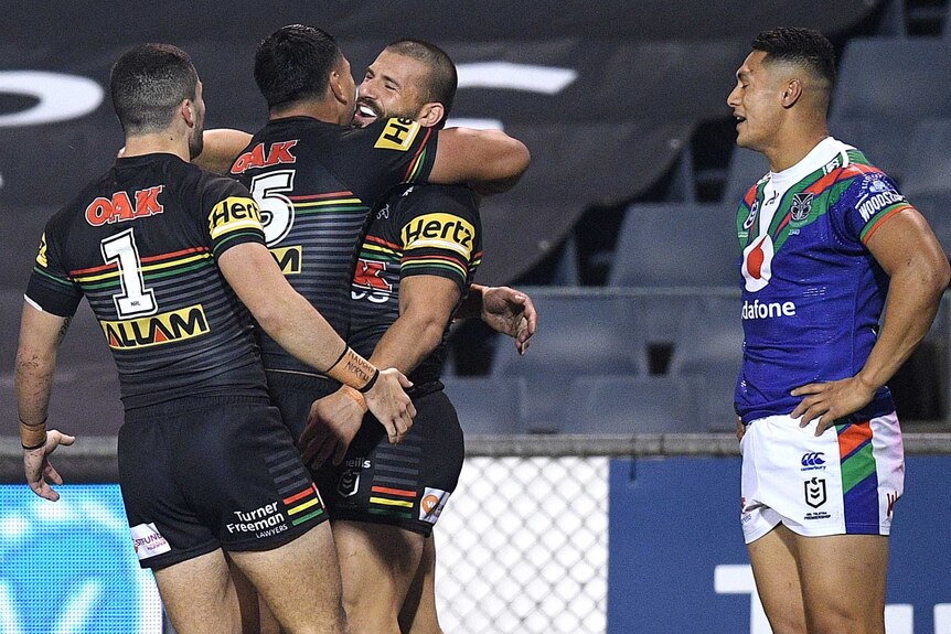Josh Mansour is hugged by Penrith Panthers teammates after a try in the NRL clash with the Warriors.