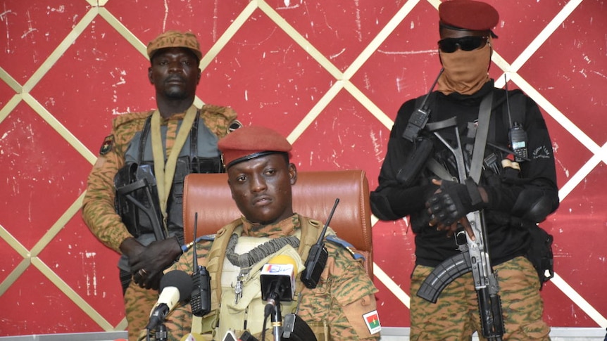 Burkina Faso coup leader Ibrahim Traore speaks to the press flanked by armed soldiers