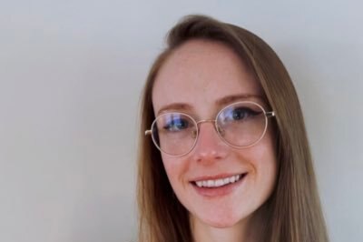 A young woman with glasses smiles