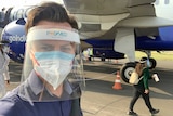 Man wearing two masks and face shield on tarmac at airport.
