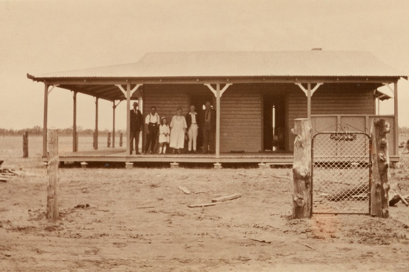 Old image of Binya hospital with a few staff in front.