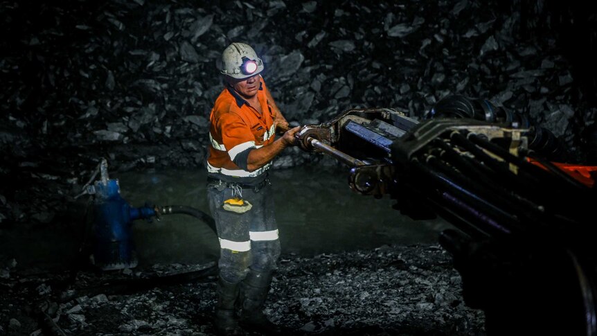 A gold miner drilling with an oversized machine