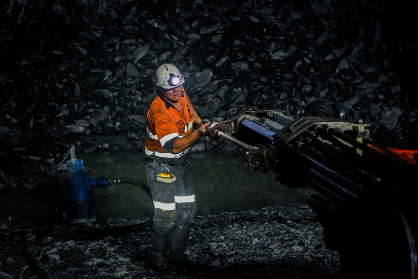 A gold miner drilling with an oversized machine