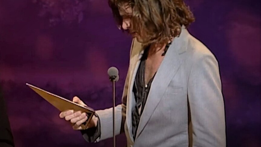 man standing with ARIA award