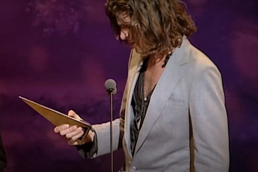 man standing with ARIA award